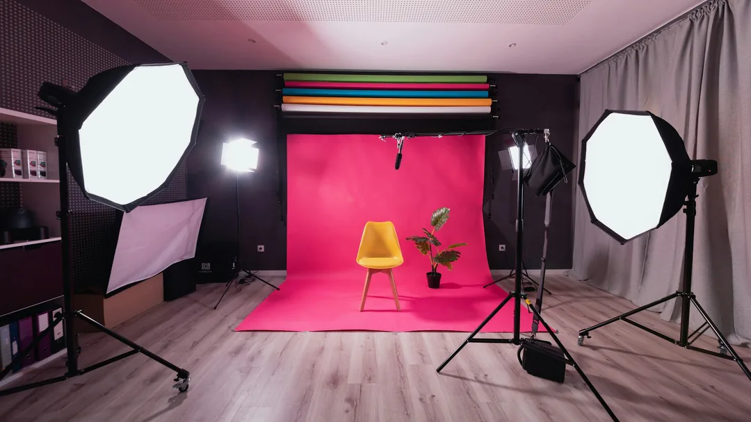 Fotografický ateliér s papírovým pozadím, stativem a postavenými studiovými světly